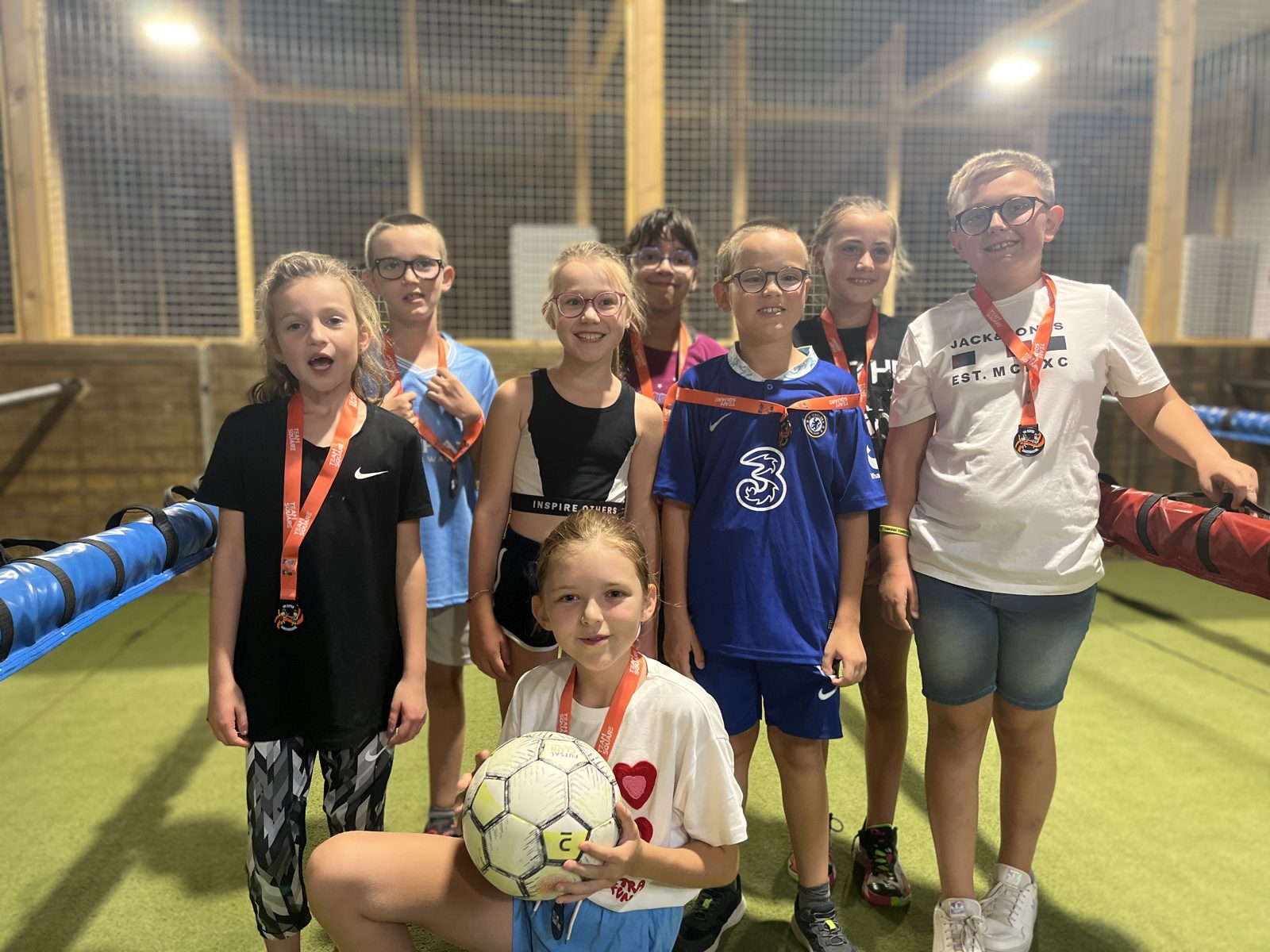 Un groupe d'enfants avec leurs médailles Team Square après une partie de Babyfoot Humain